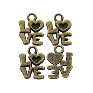 Detail of four vintage bronze LOVE charms with heart motifs for DIY jewelry making