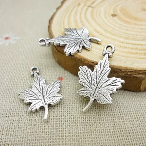 Macro detail of maple leaf alloy pendants showing intricate vein textures and metal rings