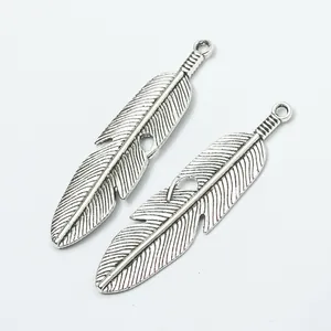 Vue détaillée de deux pendentifs plumes en alliage argenté vintage aux textures fines
