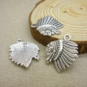 Macro view of vintage silver Indian tribal head pendants on wood for DIY jewelry