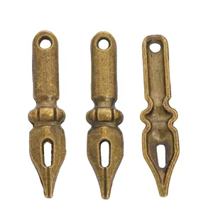 Detailed macro view of vintage bronze pen nib shaped metal pendants with antique texture