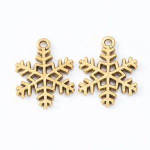 Macro shot of two vintage gold snowflake alloy charms with textured metal finish