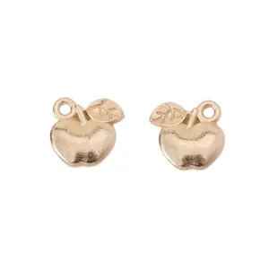 Detail view of golden apple alloy pendants with leaf design and hanging loops