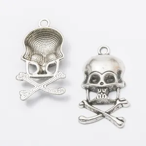 Vintage silver skull and crossbones metal charms showing front and back details