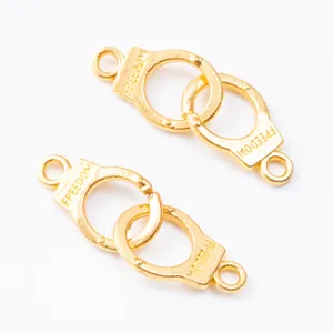Detailed macro view of gold-plated handcuff charms with Freedom engraving for DIY jewelry