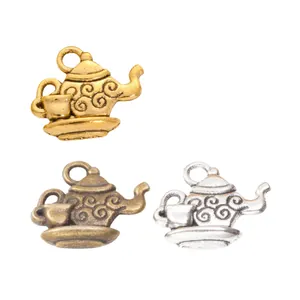 Three vintage alloy teapot charms in gold, bronze, and silver finishes with elegant details