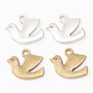 Macro detail of bird-shaped alloy pendants in silver and bronze finishes for DIY jewelry