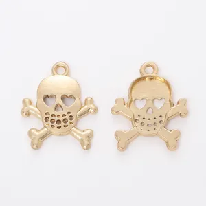 Macro shot of gold skull and crossbones pendants showing front and back alloy details