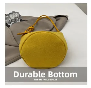 Detailed view of wear-resistant circular bottom and premium yellow suede fabric of bucket bag