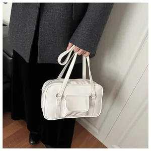 Detailed view of the white faux leather tote bag with small front flap pocket and handles