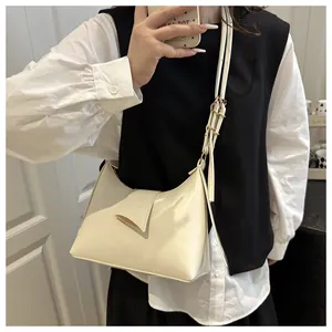 Détail du sac sous l'aisselle crème en similicuir lisse avec boucle dorée élégante