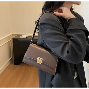 Detail view of the vintage dark brown shoulder bag with a matte finish and gold square clasp