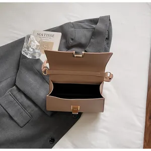 Top view of open minimalist baguette bag in light coffee PU leather with gold hardware