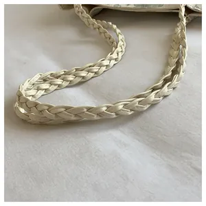 Detailed macro view of woven cream leather strap on floral print shoulder bag