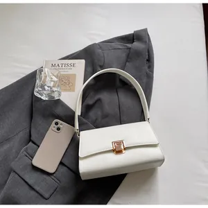 Macro shot of minimalist white baguette bag with elegant gold rectangle buckle and smooth leather