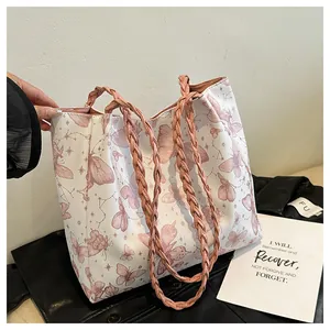 Macro shot of large capacity tote bag featuring pink butterfly prints and woven handles