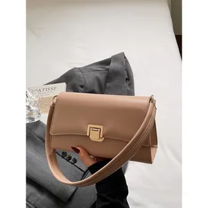 French vintage brown baguette shoulder bag with gold metal buckle on white fabric background