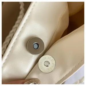 Detailed macro view of cream PU leather bag featuring magnetic snap closure and texture