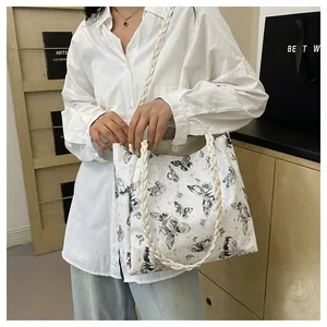Detail of butterfly print tote bag showing woven handles and magnetic clasp