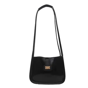 Minimalist black glossy leather underarm bag with gold logo plate and dual shoulder straps