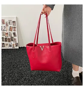 Detailaufnahme der roten Ledertasche mit elegantem goldenem Metall-V-Logo-Element