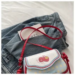 Detailed view of apple patch and wavy stitch on a lace-up patchwork crossbody bag
