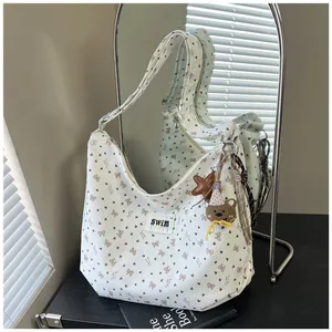 Detalle de bolso tote vintage con estampados de corazones, lazos y un colgante de oso