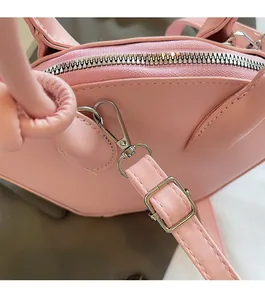 Gros plan d'un sac à main rose montrant la fermeture éclair et le fermoir mousqueton
