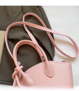 Détail du sac à main rose en cuir avec bandoulière réglable et ferrures métalliques