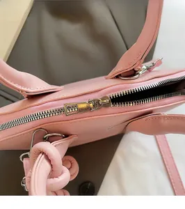 Détail du sac coquillage rose montrant les fermetures éclair et ferrures dorées