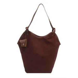 Sac seau femme en daim marron foncé avec fine bandoulière et pendentif décoratif