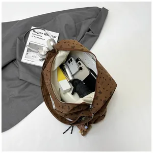 Detalle del bolso tote de pana marrón con estampados de corazones y mariposas