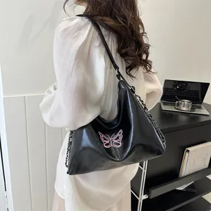 Minimalist black glossy shoulder bag with pink butterfly embroidery and metal chain strap