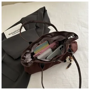 Vue détaillée du grand sac cabas en daim marron avec contenu pour les essentiels du quotidien