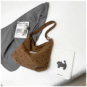 Detalle de bolso tote de pana marrón con lazos y un parche con el logotipo Swim