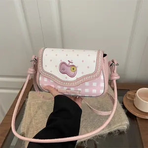Detailed view of pink lace patchwork crossbody bag with cherry embroidery and bow