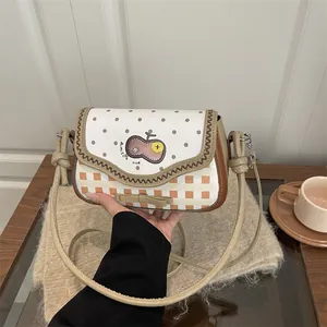Detail of cute crossbody bag with polka dots, checkerboard pattern and bow decoration