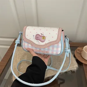 Detail of pink and blue lace patchwork crossbody bag with bow and cartoon patch
