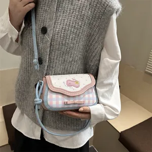 Detail of adjustable blue leather strap and lace-edge patchwork bag shown on a model