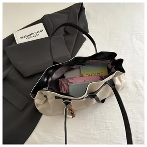 Vue de dessus du grand sac fourre-tout crème montrant l'intérieur spacieux et la poche zippée