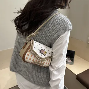 Close-up of retro shoulder bag with lace edges, plaid pattern and apple patch detail