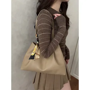 Khaki leather tote bag with printed silk scarf detail, styled for elegant shoulder carry