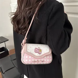 Pink and white patchwork shoulder bag with polka dots and bow detail shown on a model