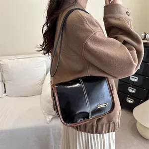 Sac à bandoulière classique en cuir noir pour femme avec bordure brune et surpiqûres