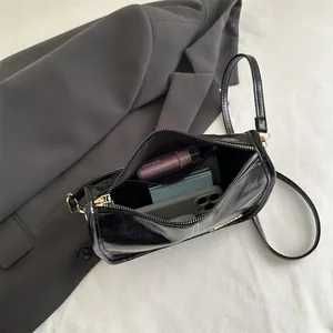Sac à bandoulière noir brillant pour femme, style minimaliste avec détails dorés