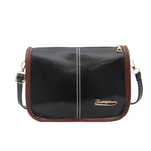 Sac à bandoulière noir brillant minimaliste avec bordure marron et logo doré poli
