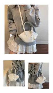 Détail d'un sac à main blanc en forme de coquille en cuir avec poignée et bandoulière