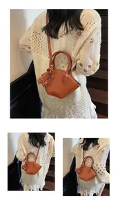 Détail du sac coquillage camel avec breloque nœud en cuir et finitions argentées