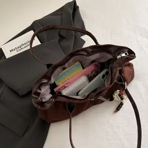 Grand sac cabas en velours côtelé marron contenant un ordinateur et des accessoires