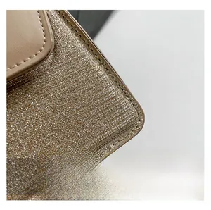 Close-up of glitter sequins fabric and beige leather stitching on a small handbag